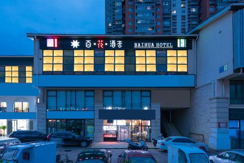 a building with cars parked in a parking lot at Baihua Hotel in Beijing