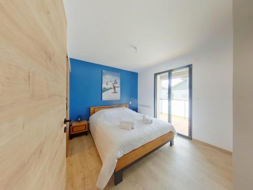 a bedroom with a bed and a blue wall at Villa neuve aux Rousses, proche centre, jusqu'à 12 personnes - FR-1-834-5 in Les Rousses