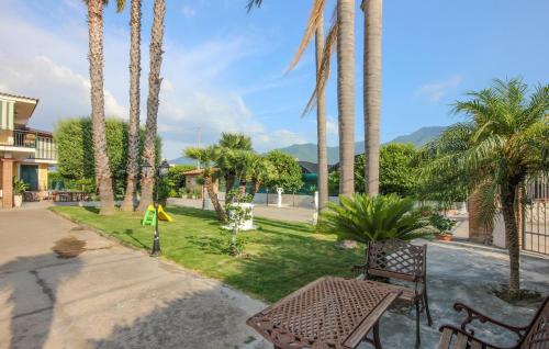a park with palm trees and two benches at Villa Angela Holiday Apartment in Angri