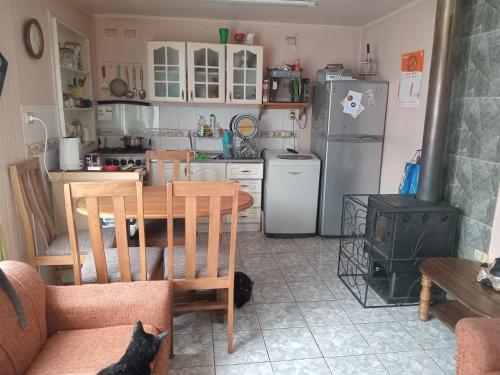 a kitchen with a table and a kitchen with a stove at Habitación a pasos de la playa in Puerto Varas
