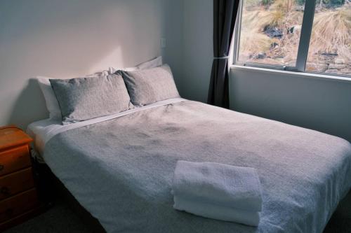a bedroom with a large bed with a window at 18 Jimmys Apartment in Lake Tekapo