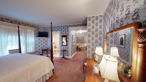 a bedroom with a bed and floral wallpaper at The Red Lion Inn in Stockbridge