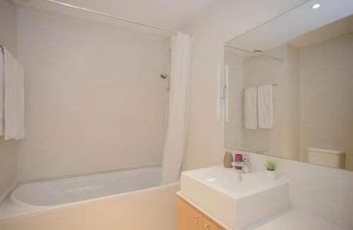 a white bathroom with a sink and a bath tub at Oporto Blue Dragão - Modern Uptown Studio With Free Parking in Porto