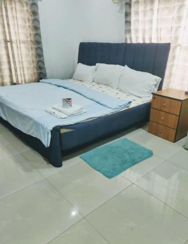 a bed with a blue bed frame and a night stand at st theresas homes in Lagos