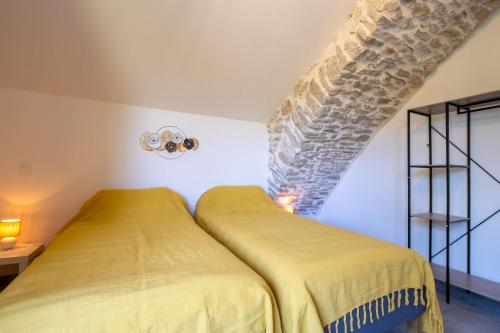 a bedroom with two beds in a room at Le p'tit pelet in Fraissinet-de-Fourques
