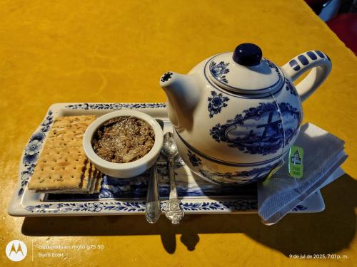 a blue and white teapot on a plate with a bowl of food at Buriti EcoH RNT56521, via Termales Santa Rosa de Cabal in Santa Rosa de Cabal