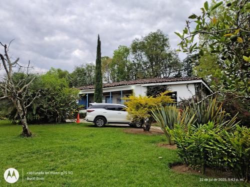 a white car parked in front of a house at Buriti EcoH RNT56521, via Termales Santa Rosa de Cabal in Santa Rosa de Cabal