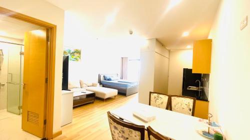 une cuisine et un salon avec une table et des chaises dans l'établissement GRAND HYCHARMS serviced STUDIO, à Quy Nhơn