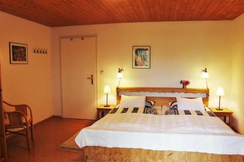 a bedroom with a large bed with two tables and two lamps at Landhaus Heinrich in Ruhpolding