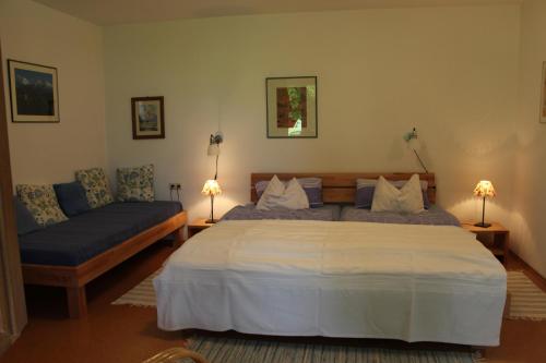 a bedroom with a large bed and a couch at Landhaus Heinrich in Ruhpolding