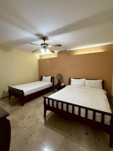 a bedroom with two beds and a ceiling fan at ซิลเวอร์วู้ด รีสอร์ท in Ban Phai Bo Pla Lai