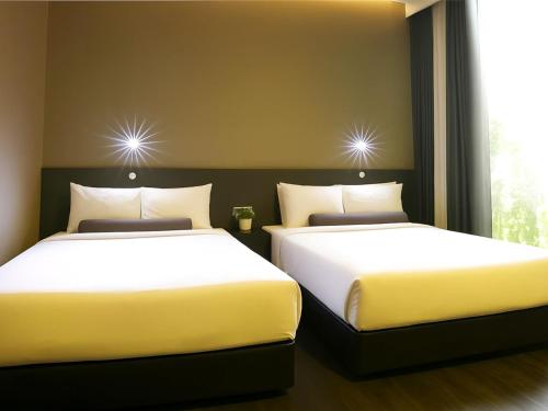 two beds sitting next to each other in a room at Seeds Hotel Premier One City Subang Previously eCity Hotel One City in Subang Jaya