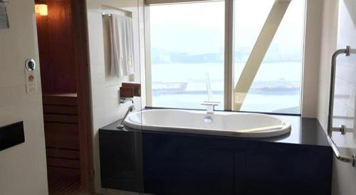 a bathroom with a tub with a large window at Grand Lisboa Macau in Macau