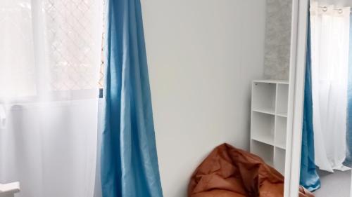 a room with blue curtains and a shelf at Peaceful Forest Retreat and Hot Tub in Russell Island