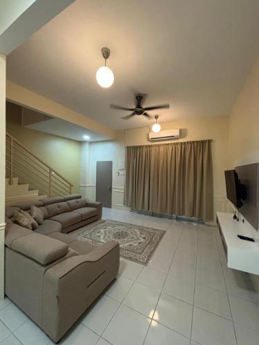 a large living room with a couch and a tv at Nameera Stay Bandar Universiti Seri Iskandar in Seri Iskandar