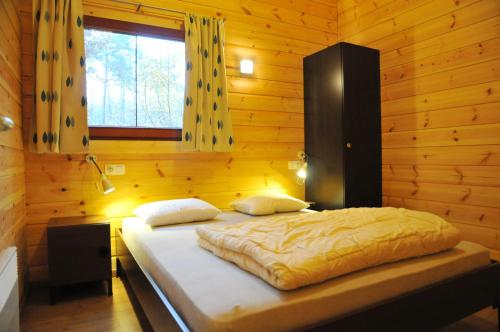 a bedroom with a bed in a wooden room at Abri Vert in Oignies-en-Thierache