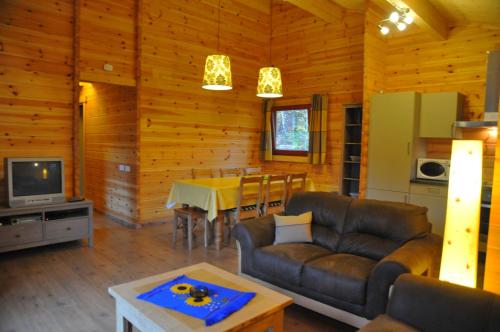 a living room with a couch and a table at Abri Vert in Oignies-en-Thierache