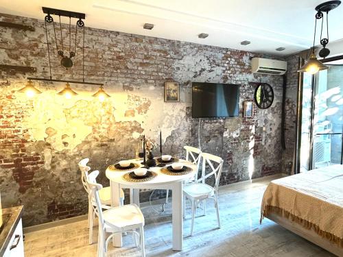 Un comedor con una mesa y sillas blancas. en Дизайнерско студио ,Смокиня,Созопол,5 звезден затворен комплекс,4 басейна,1ва линия море, en Sozopol