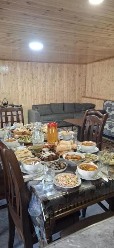 a table with plates of food on it at Guesthouse "MEGI" in Mestia