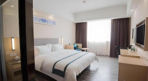 a hotel room with a large bed and a television at City Comfort Inn Shantou Daxue Road in Shantou