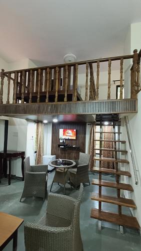 a living room with a spiral staircase and chairs at Nivaant at Vicharays Plus in Revadanda