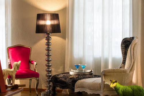 a living room with a table and chairs and a lamp at A for Art Hotel in Limenas