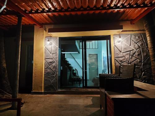 a room with a glass door with chairs and a staircase at Nivaant at Vicharays Plus in Revadanda