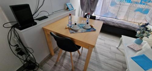 a small table with a chair in a room at Comfortable studio in Bevaix with mountain view - 30 m² + Spa in Bevaix