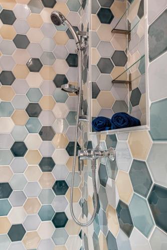 La salle de bains est pourvue d'une douche, d'un miroir et de carrelage. dans l'établissement La Casa Nissarte - Centre ville prés gare - wifi -parking , confort et cosy, à Nice