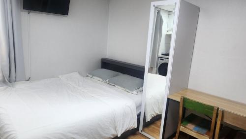 a small bedroom with a bed and a mirror at Kiman09 in Seoul