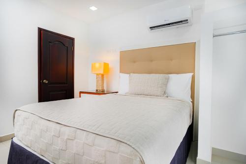 a white bedroom with a large bed in a room at Muna Hotel in San Pedro Sula