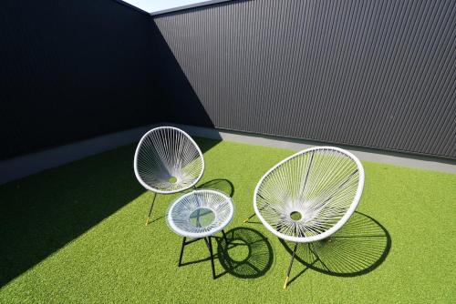 three chairs sitting on the grass in a building at 61 Fuji Petel UN -アン- in Fujikawaguchiko