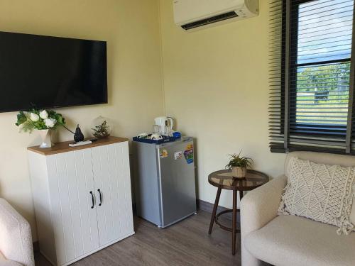 a living room with a refrigerator and a tv on the wall at Nordika Hill in Pak Chong