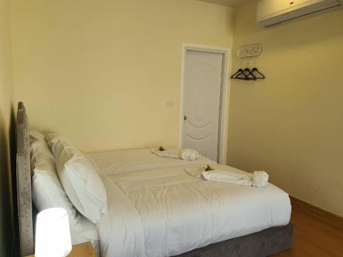 a bedroom with a bed with white sheets and pillows at Nordika Hill in Pak Chong