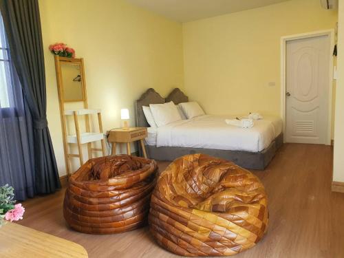 a bedroom with two beds and two large ottomans at Nordika Hill in Pak Chong