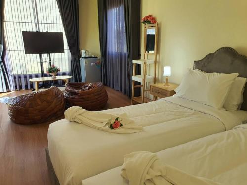a bedroom with a large white bed with a flower on it at Nordika Hill in Pak Chong