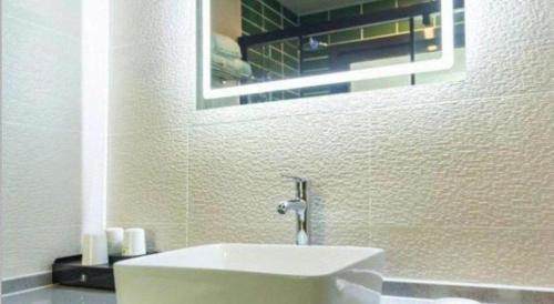 a bathroom with a white sink and a mirror at GreenTree Inn Express Datong High-Speed Railway Station Wanda Plaza Fangte in Datong
