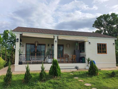 a small white house with a porch at Nordika Hill in Pak Chong
