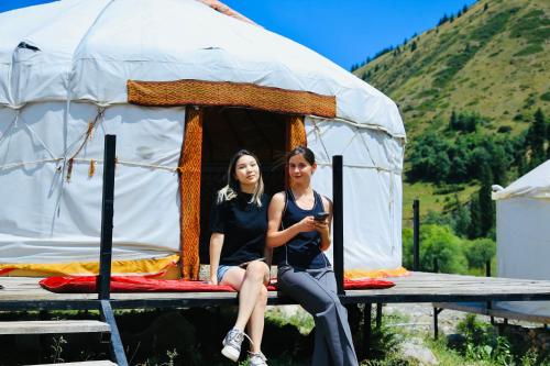 two women are sitting in a tent at Отель юрта Kaindy in Kurmenty