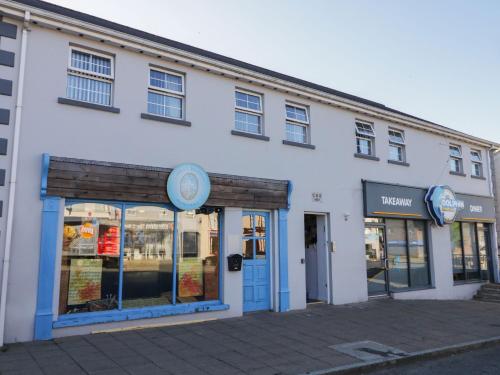 a white building with blue doors and windows at Shalom Apartment 98B in Armagh