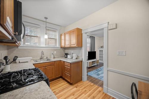 a kitchen with wooden cabinets and a stove top oven at Modern 1 Bdr Apt King bed Sleeps4 in Pittsburgh