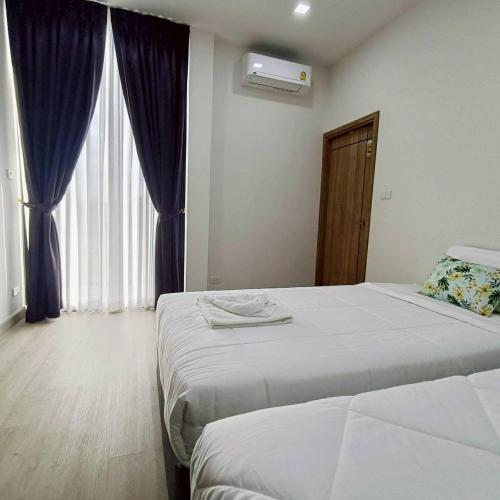 a hotel room with two beds and a window at Nordika Hill in Pak Chong
