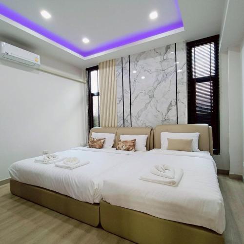 a bedroom with a large bed with two cats sitting on it at Nordika Hill in Pak Chong