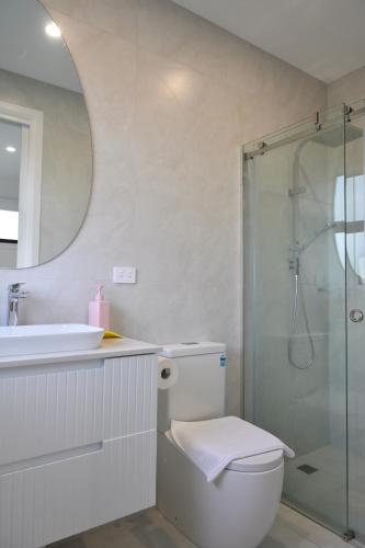 a bathroom with a toilet and a sink and a shower at Entire House Stay in Springvale in Springvale