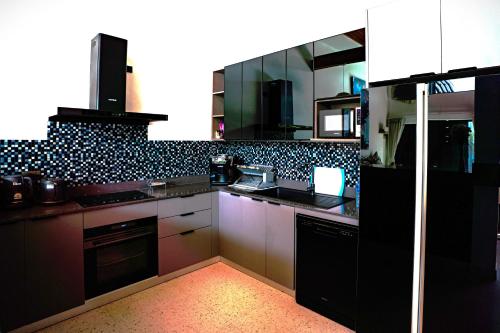 a kitchen with black and white tiles on the wall at Rawai Villa in Rawai Beach
