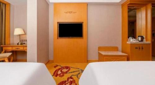 a hotel room with a bed and a television at Vienna Hotel Guangxi Fangcheng in Fangcheng