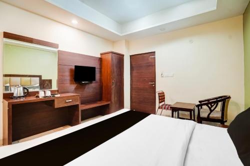 a bedroom with a bed and a desk and a television at Super Townhouse Sikar Road Jaipur Formerly Hotel Aroma Inn in Jaipur
