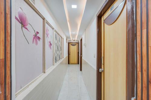 a corridor of a hallway with pink flowers on the walls at Super Collection O Maninagar East Formerly Maninagar Residency in Ahmedabad