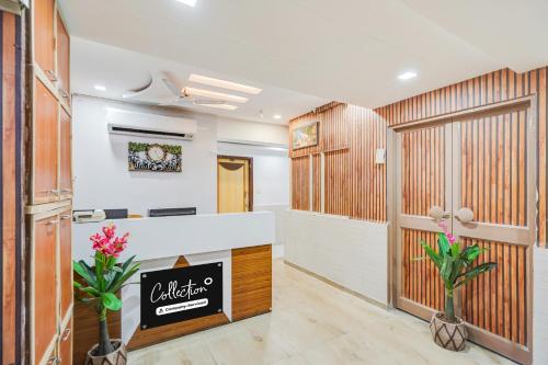 an office lobby with a reception desk and flowers at Super Collection O Maninagar East Formerly Maninagar Residency in Ahmedabad