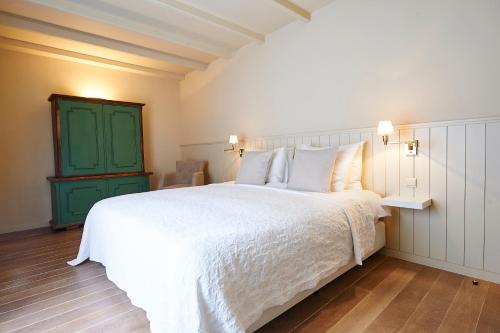 - une chambre avec un lit blanc et une porte verte dans l'établissement B&B Maryline, à Anvers